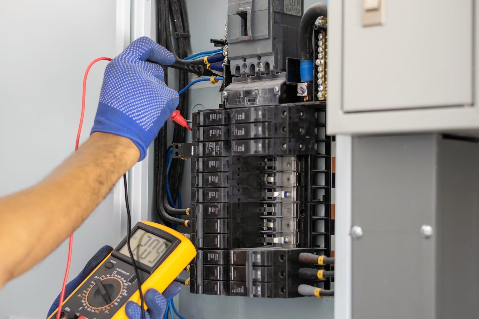 Electrician testing a residential panel with a multimeter