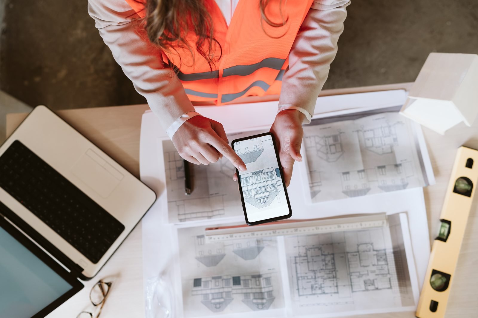 Engineer reviewing plans with a phone overlay