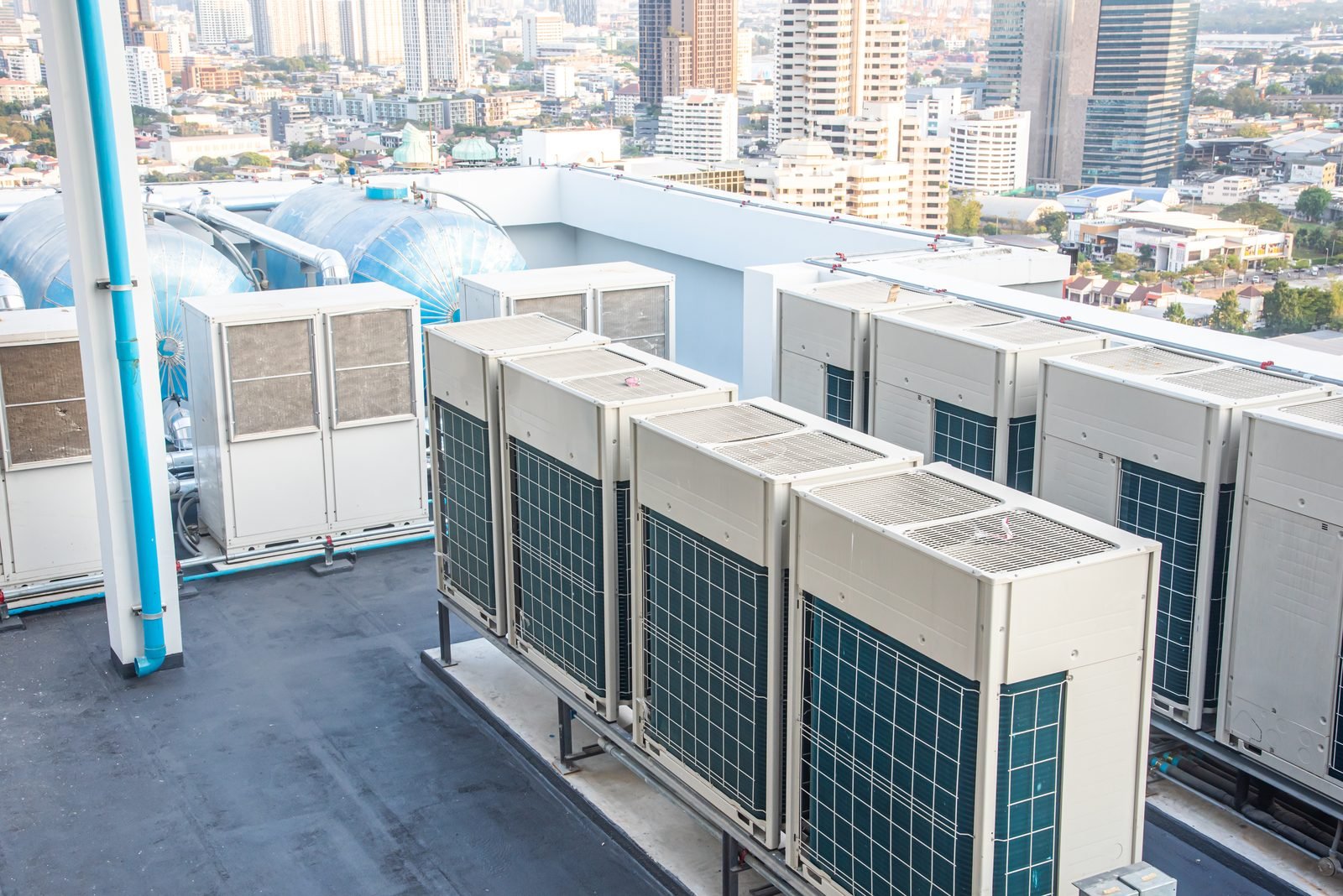 Bank of HVAC condenser units on a city rooftop