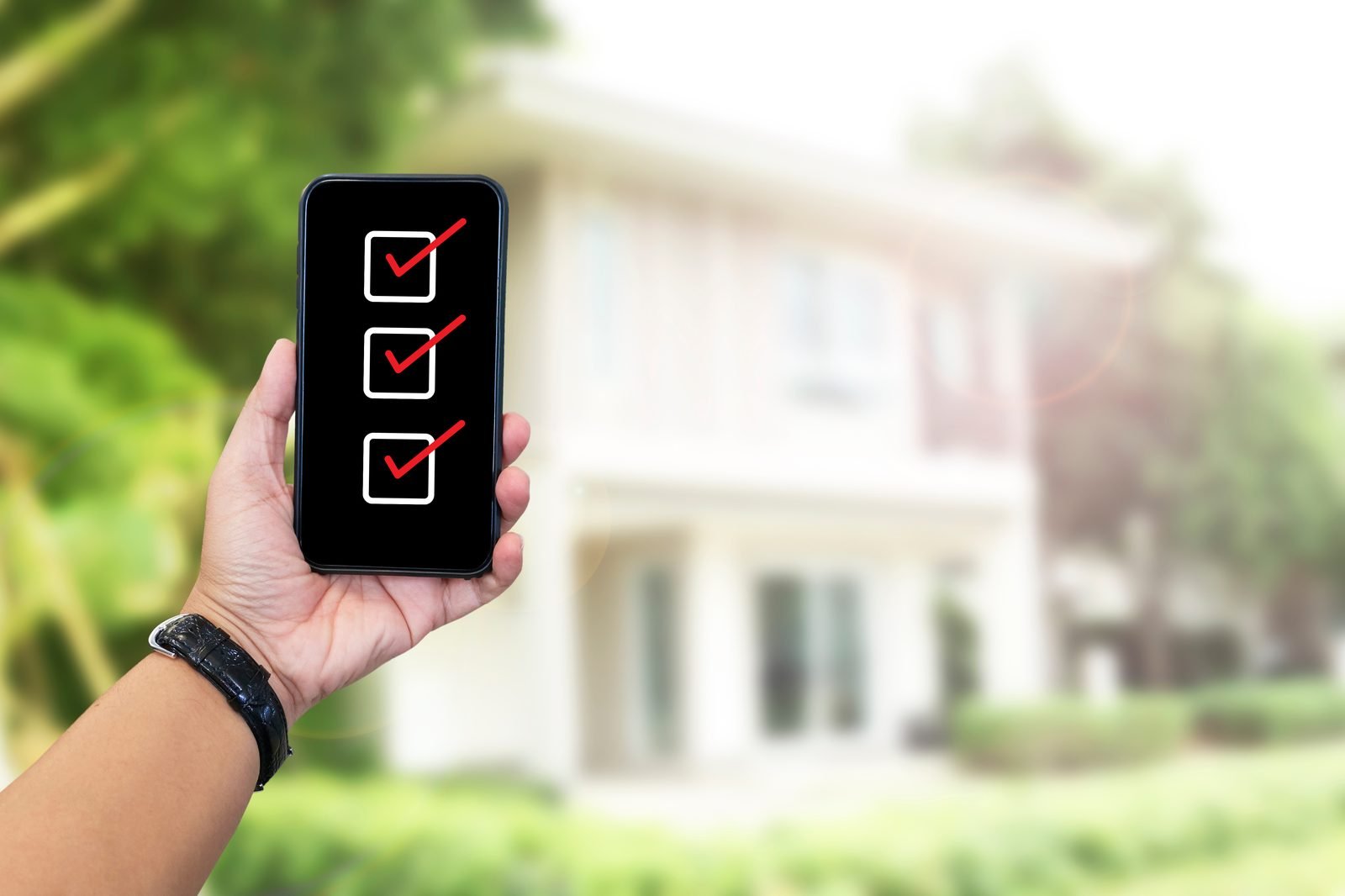 Inspector with a phone checklist in front of a home