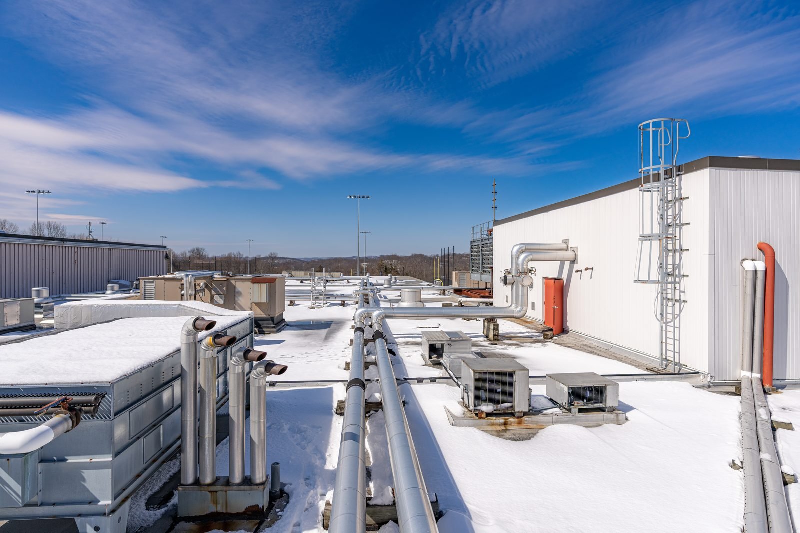 Rooftop HVAC units and ductwork against a winter sky
